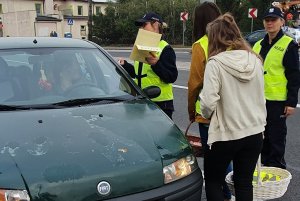 Policjantka wręcza kierowcy dyplom za rozważną jazdę