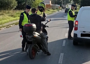 policjant kontroluje kierującego motorowerem